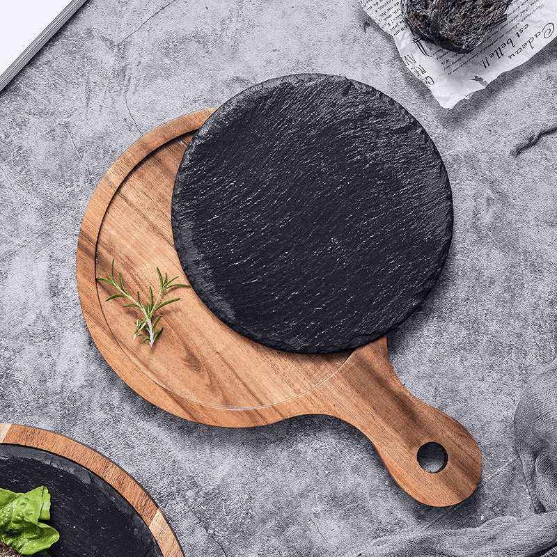 Rustik wooden serving board with slate surface and handle, featuring a round shape.
